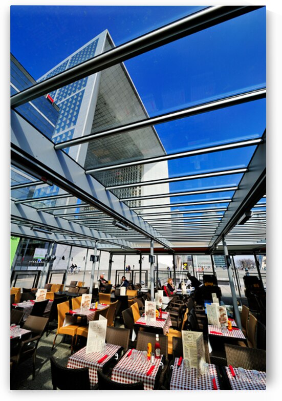 Dining area in Paris with modern building under clear sky by Marco Brivio