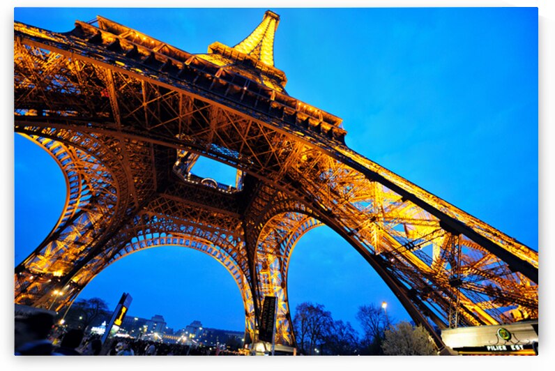 Eiffel Tower stands bright against darkening sky in Paris by Marco Brivio