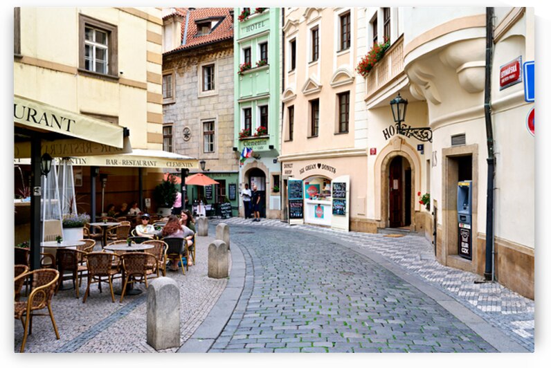 Cobblestone street in Prague with cafes shops and historic bui by Marco Brivio