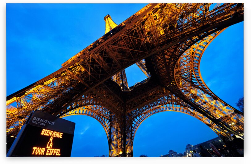 Visitors gather at the Eiffel Tower in Paris during evening hour by Marco Brivio