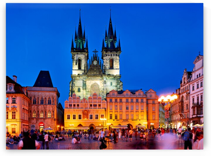 Pragues Old Town Square at night illuminated church and crowd. by Marco Brivio