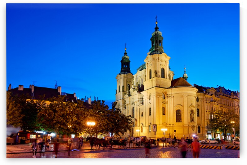 Illuminated church and lively square at night. by Marco Brivio