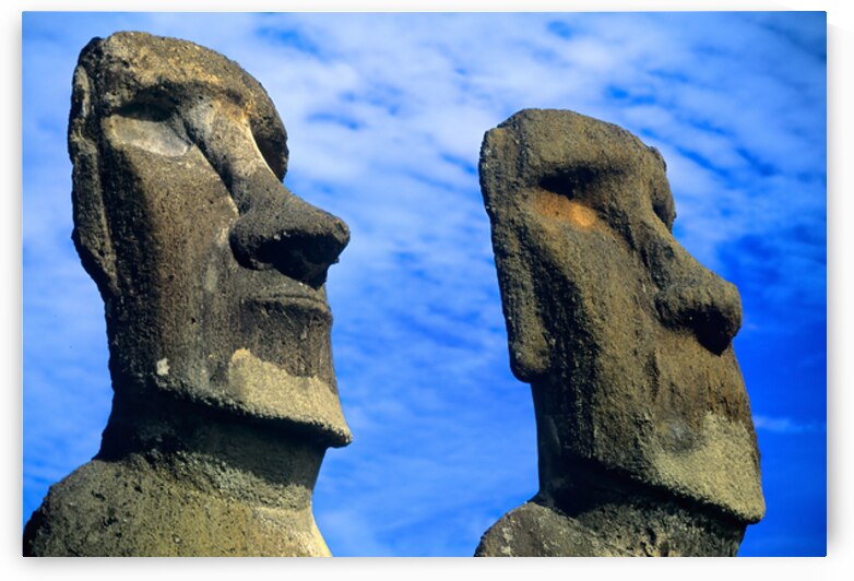 Two Moai statues against a blue sky. by Marco Brivio
