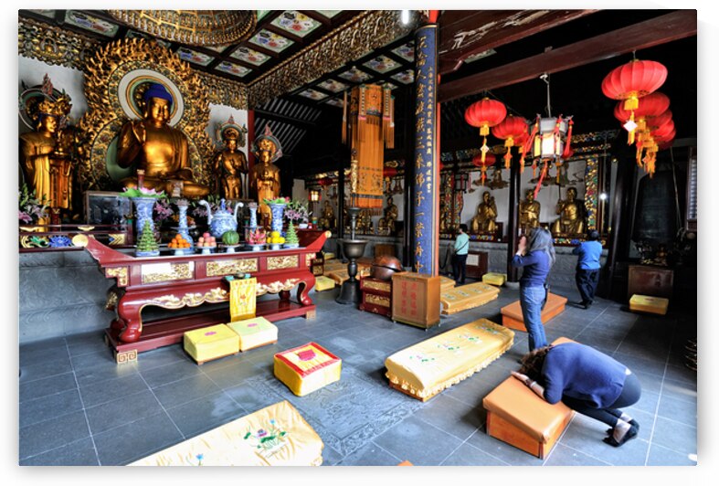 Worshippers offer prayers in a Buddhist temple in Shanghai Chin by Marco Brivio