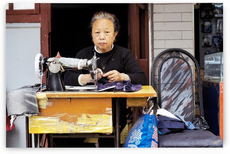 Elderly woman sews at machine in Shanghai China by Marco Brivio
