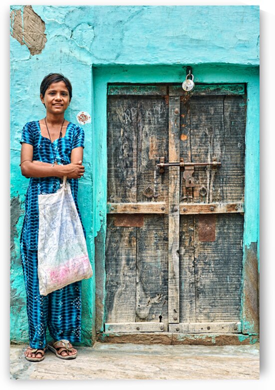 Girl standing in front of a door at her home in Mandawa India by Marco Brivio
