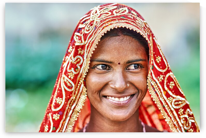 Woman in red traditional dress smiles in Rajasthan by Marco Brivio