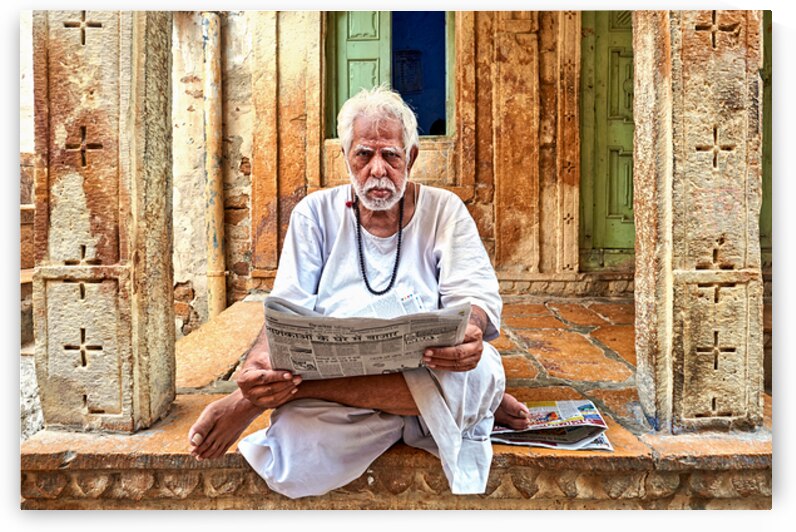 Man reads newspaper on street in Jaisalmer Rajasthan India by Marco Brivio