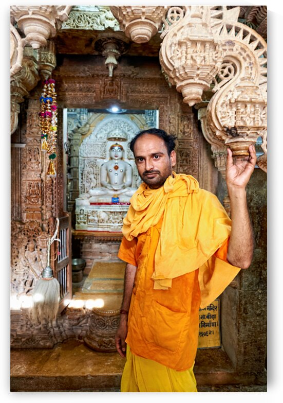 Hindu monk stands near statue in Jaisalmer Jain temple by Marco Brivio