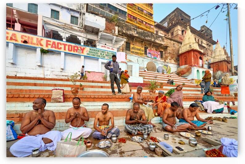 Barechested men offer prayers by the Ganges River in Varanasi by Marco Brivio