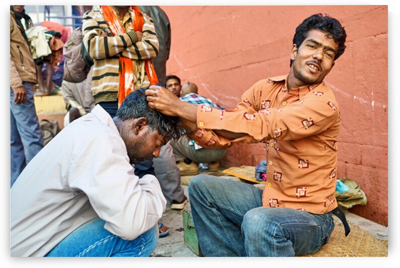 Barber cuts hair at shop in Varanasi Uttar Pradesh India by Marco Brivio