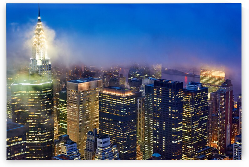 Sky view of Manhattan at dusk with city lights and fog by Marco Brivio