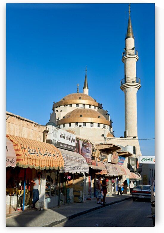 Mosque in Madaba Jordan with shops and street activity present by Marco Brivio