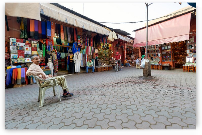 Shops in the Medina of Marrakesh with people and goods on displa by Marco Brivio