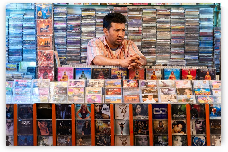Man selling CDs at a market stall in Marrakesh Morocco by Marco Brivio