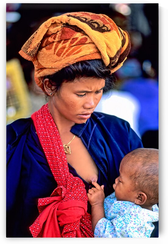 Portrait of a woman feeding her son in Myanmar market place by Marco Brivio