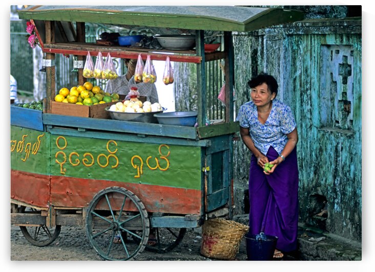 Fruit vendor at street market in Yangon during the day by Marco Brivio