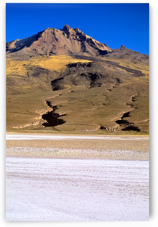 Mountain overlooks vast salt flat under clear blue sky. by Marco Brivio