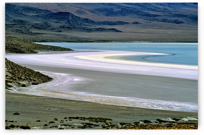 Scenic desert lake with white shore and rocky mountains. by Marco Brivio