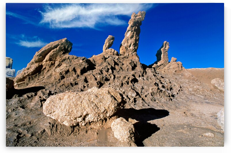Dramatic desert rock formations under a vibrant blue sky. by Marco Brivio
