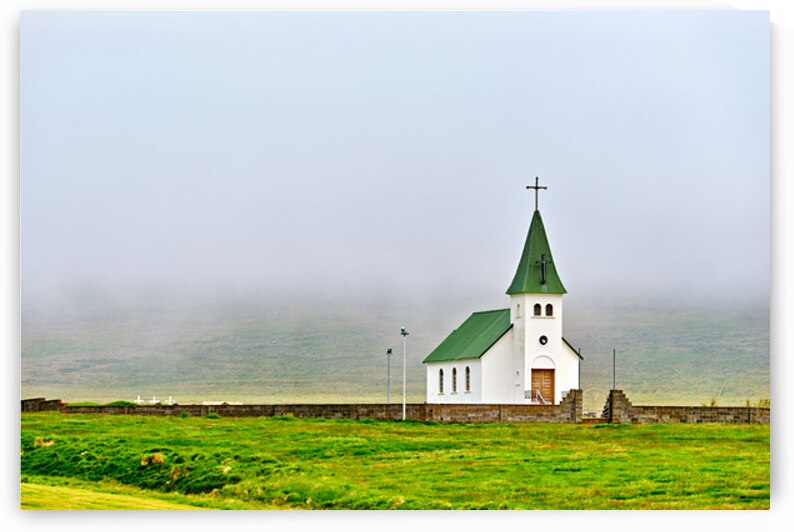Tjarnarkirkja church stands alone in foggy landscape in Iceland by Marco Brivio