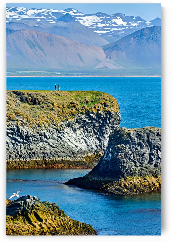 Visitors walk along the Arnarstapi cliff edge in Iceland by Marco Brivio