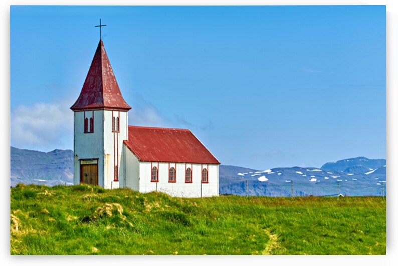 Church in Hellnar Iceland stands against blue sky and mountains by Marco Brivio