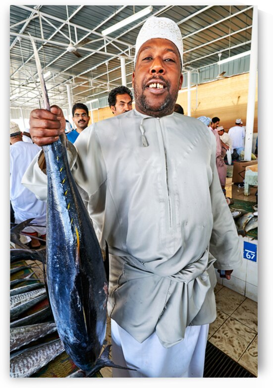Fish seller shows catch in Muscat Oman fish market by Marco Brivio