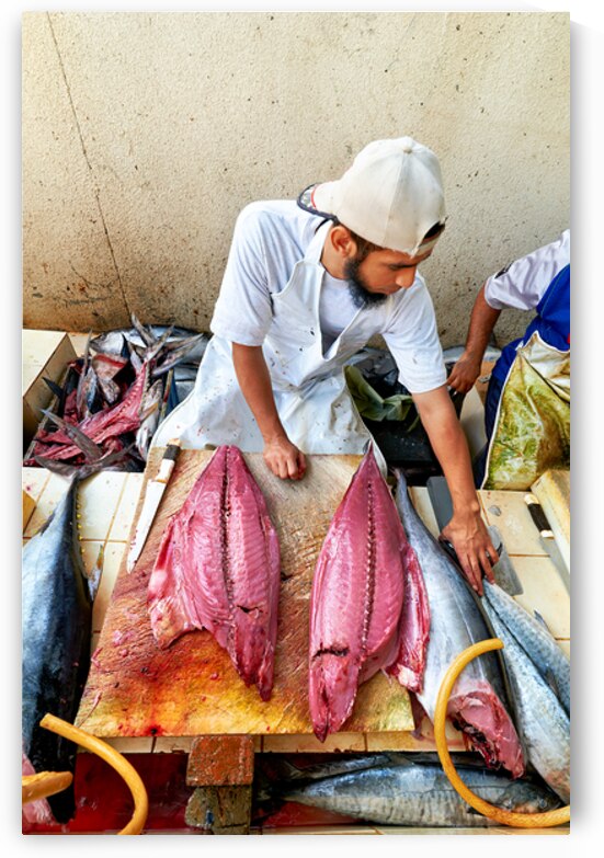 Fish market in Muscat Oman shows a vendor at work by Marco Brivio