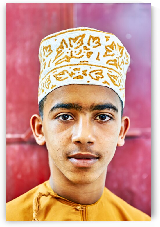 Boy in traditional dress in Muscat Oman during daytime by Marco Brivio