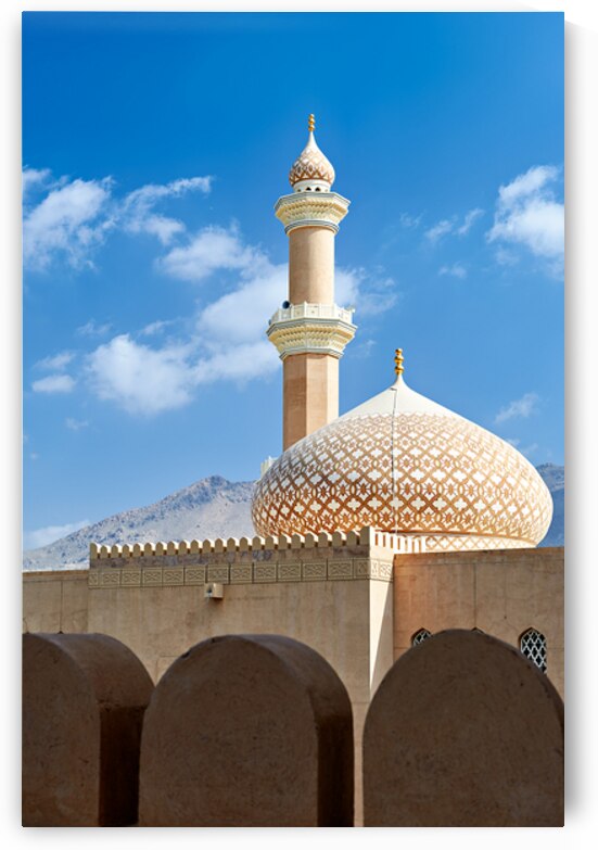 Nizwa Fort shows mosque and tower with blue sky and clouds by Marco Brivio