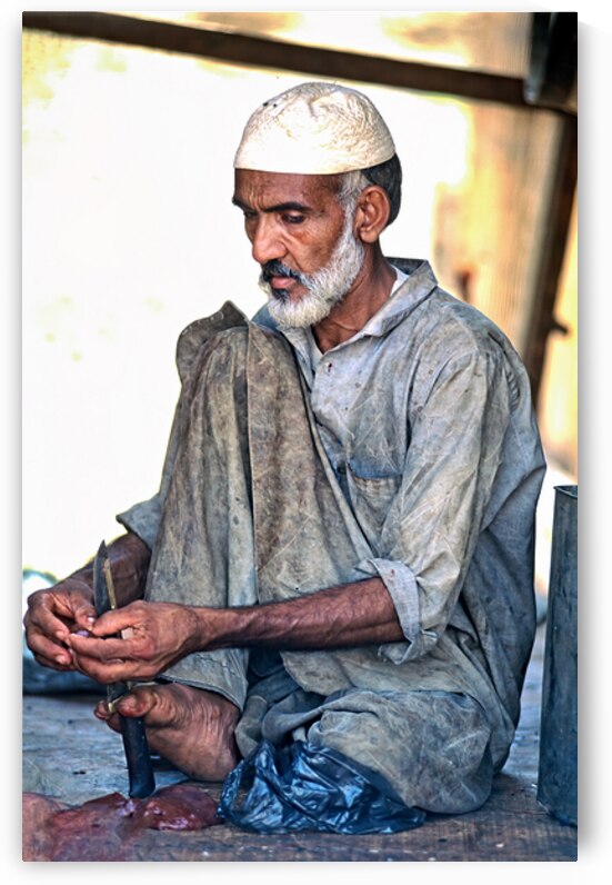 Butcher works with knife in Mingora Pakistan during day by Marco Brivio