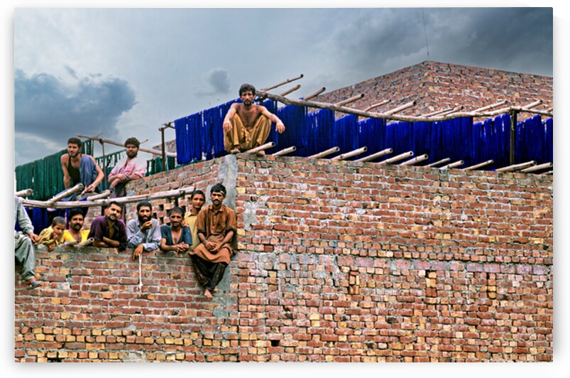 Workers rest during break time at a construction site in Lahore by Marco Brivio