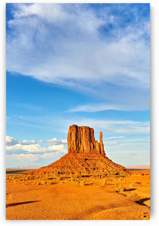 Monument Valley shows red rock formations under blue sky by Marco Brivio