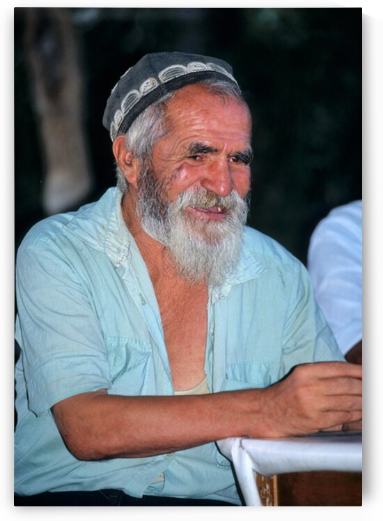 Elderly man smiles while sitting outdoors in Bukhara Uzbekistan by Marco Brivio