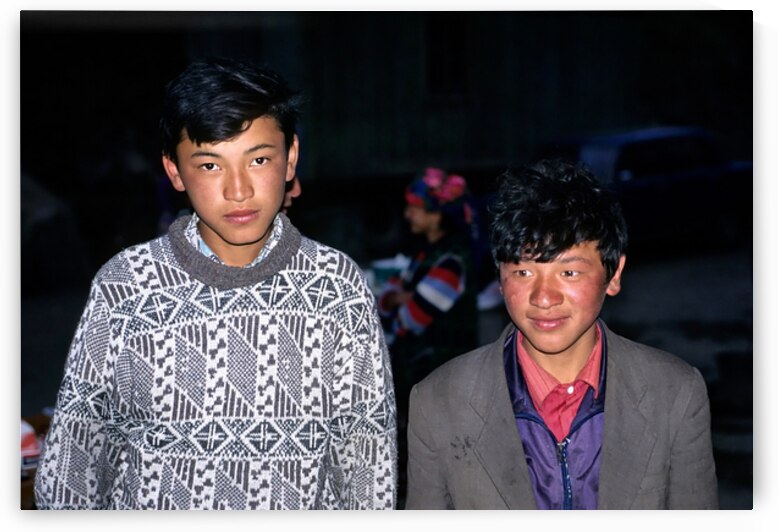 Boys stand together in Uzbekistan at night during a local event by Marco Brivio