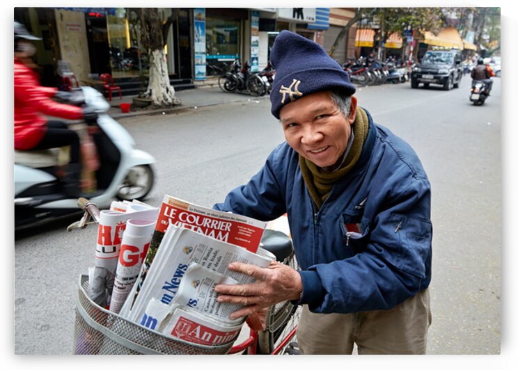 Man selling newspapers in Ho Chi Minh City by Marco Brivio