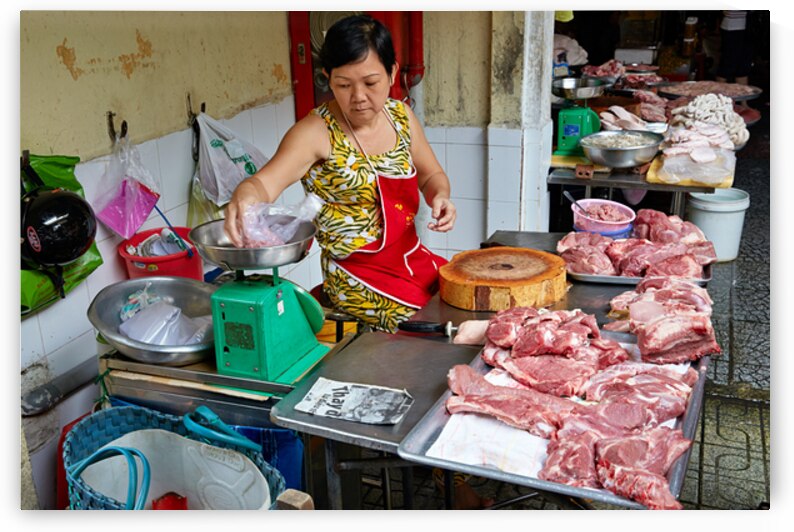 Local butcher weighs meat in Ho Chi Minh City market by Marco Brivio