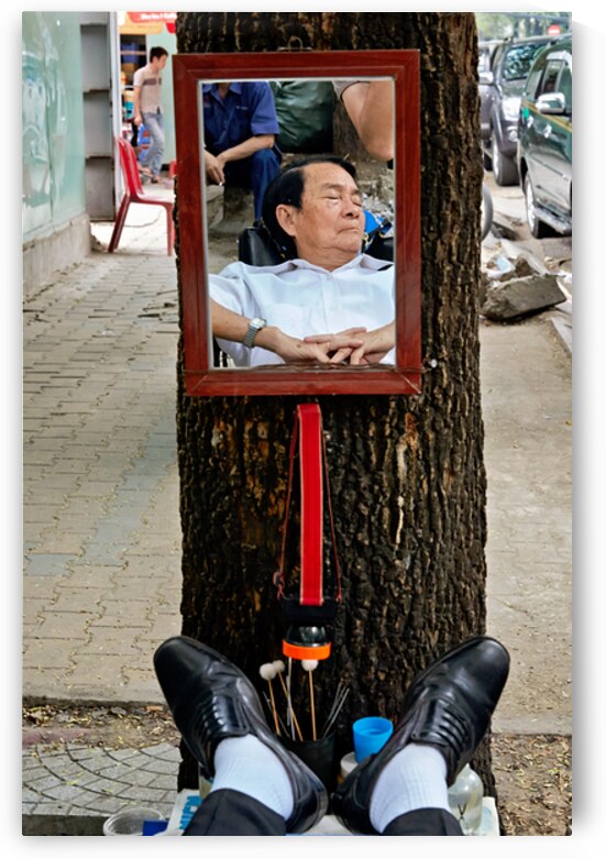 Man resting in Ho Chi Minh City with mirror reflection by Marco Brivio