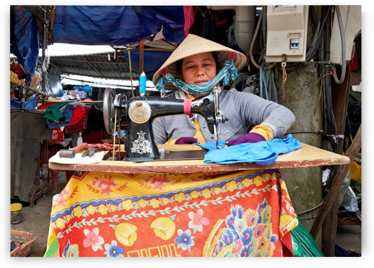 Woman sewing at a market in Phu Quoc Vietnam during the day by Marco Brivio