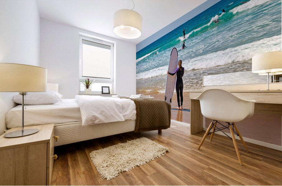 Surfer girl with surfboard on beach watching waves Mural print