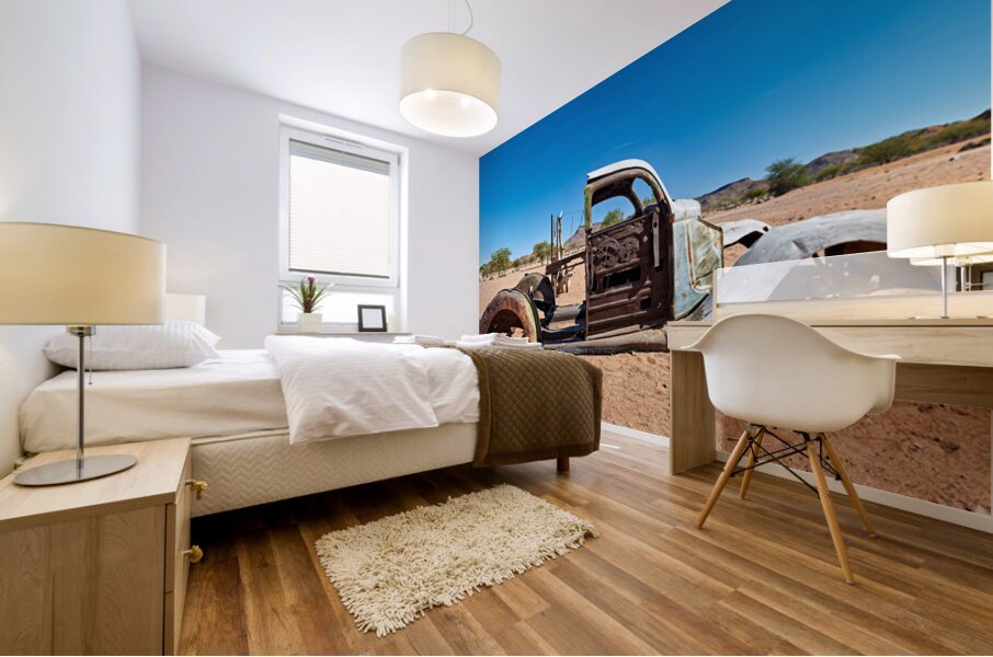 Classic car wreck rests in the Namib desert under a clear sky Mural print