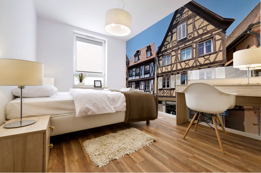 Visitors explore timber framed houses in Colmar Alsace on a sun Mural print