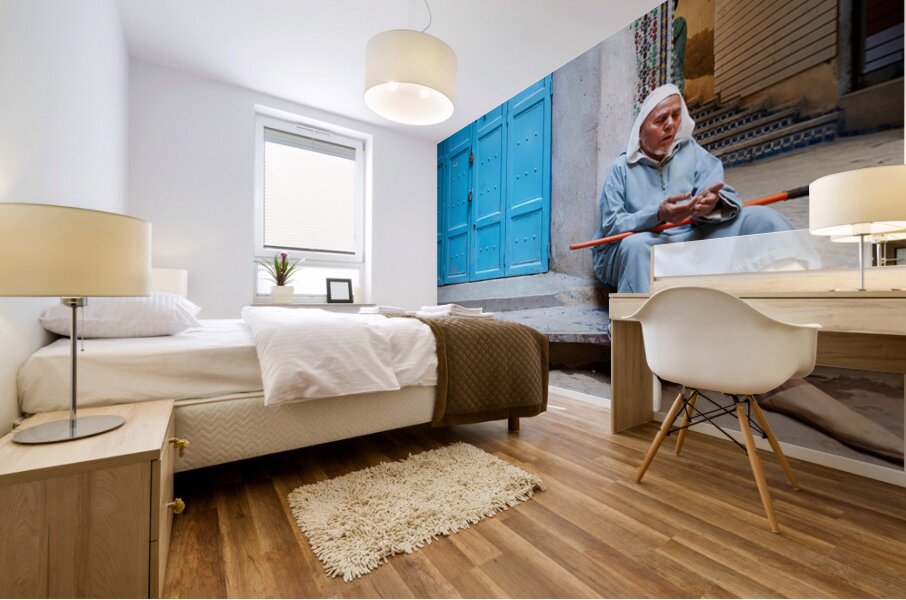 Portrait of a beggar sitting by a blue door in Fez Morocco Mural print