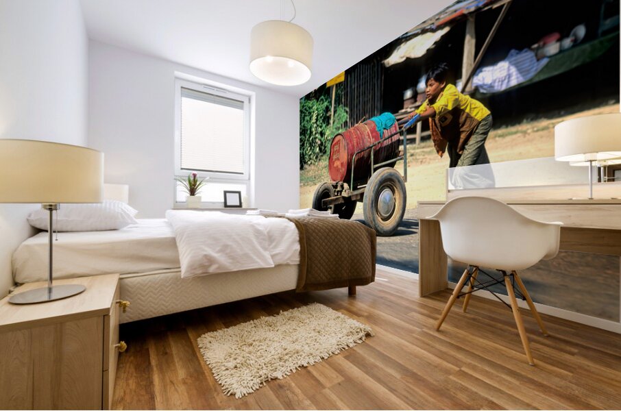 Boy pushes a cart down the street in Myanmar during the day Mural print