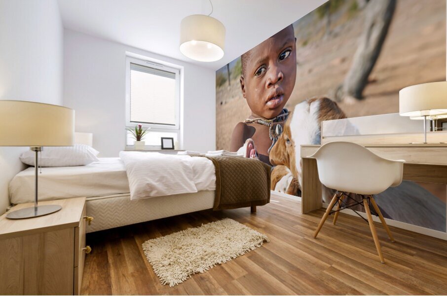 Child carries goats in Himba village of Namibia Kunene Region Mural print