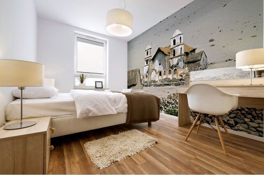 Dilapidated church and stone buildings in a barren desert landsc Mural print