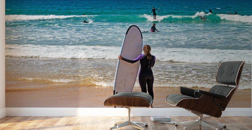 Surfer girl with surfboard on beach watching waves Wall Murals