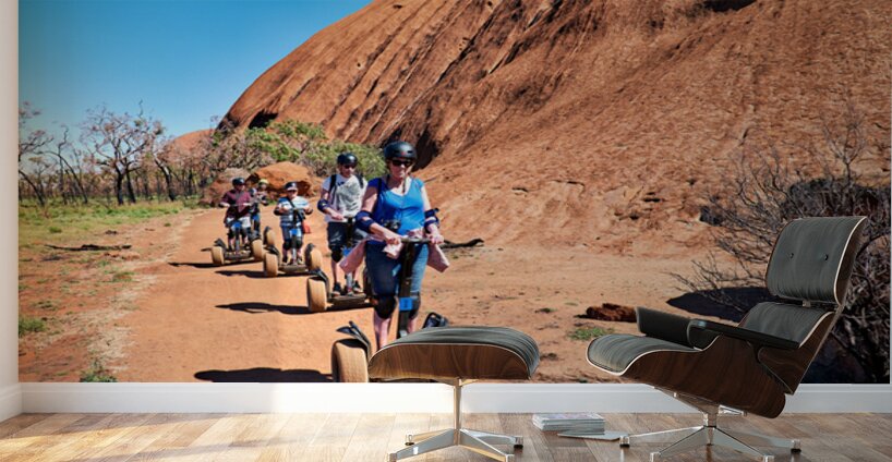 Tourists ride Segways near Uluru in Australia. Wall Murals