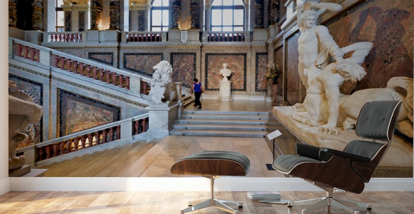 Ornate museum hall with statues grand staircase and visitor. Wall Murals